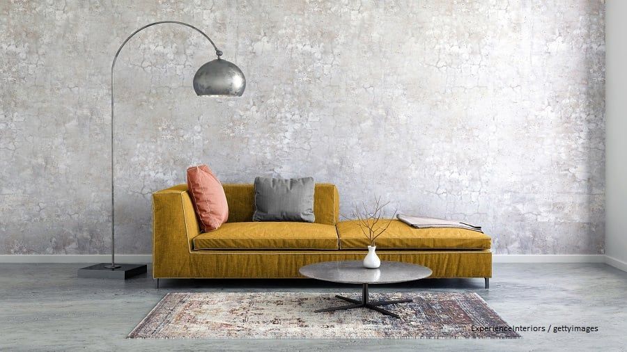 Senfgelbes Sofa vor grauer Wand
