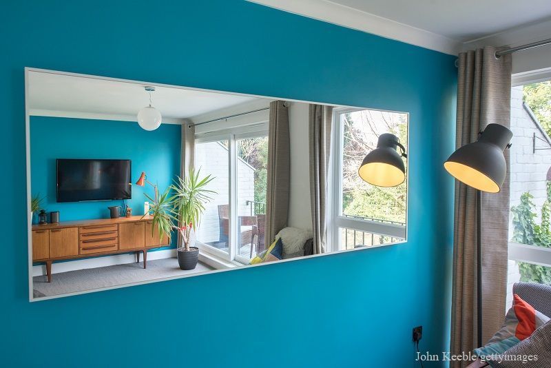 Großer Spiegel an blauer Wand