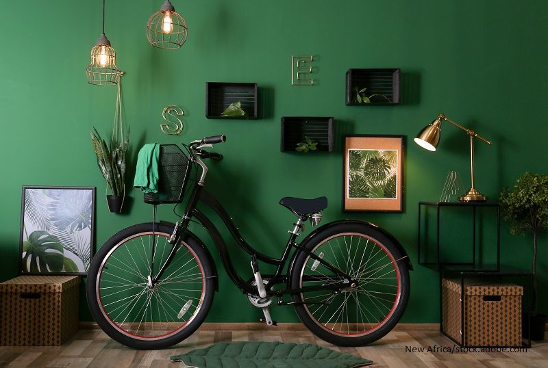 Stylischer Flur mit grüner Wand und Fahrrad. 